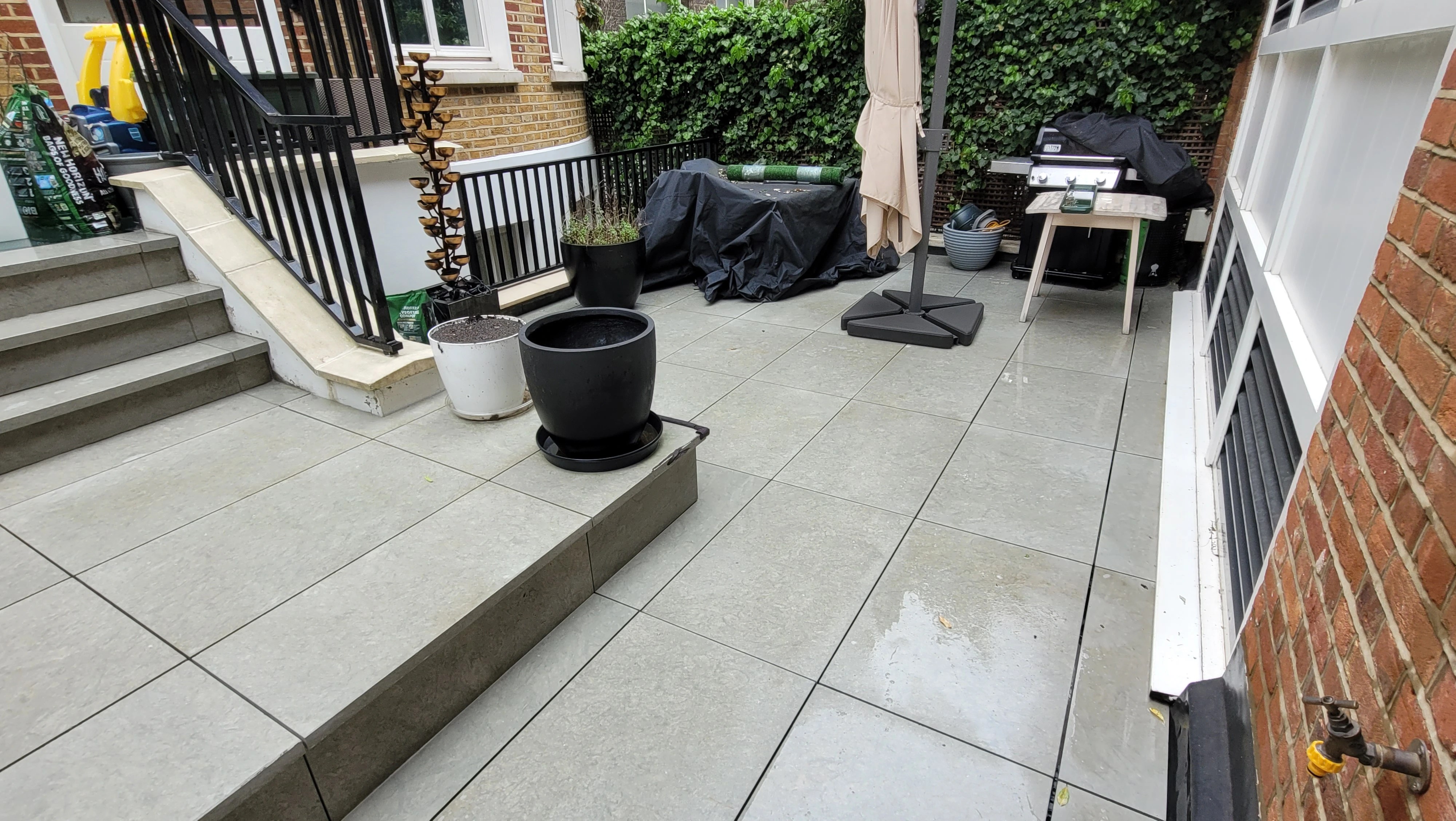 Restored outdoor porcelain tiles looking like new after low pressure soft washing in Crawley